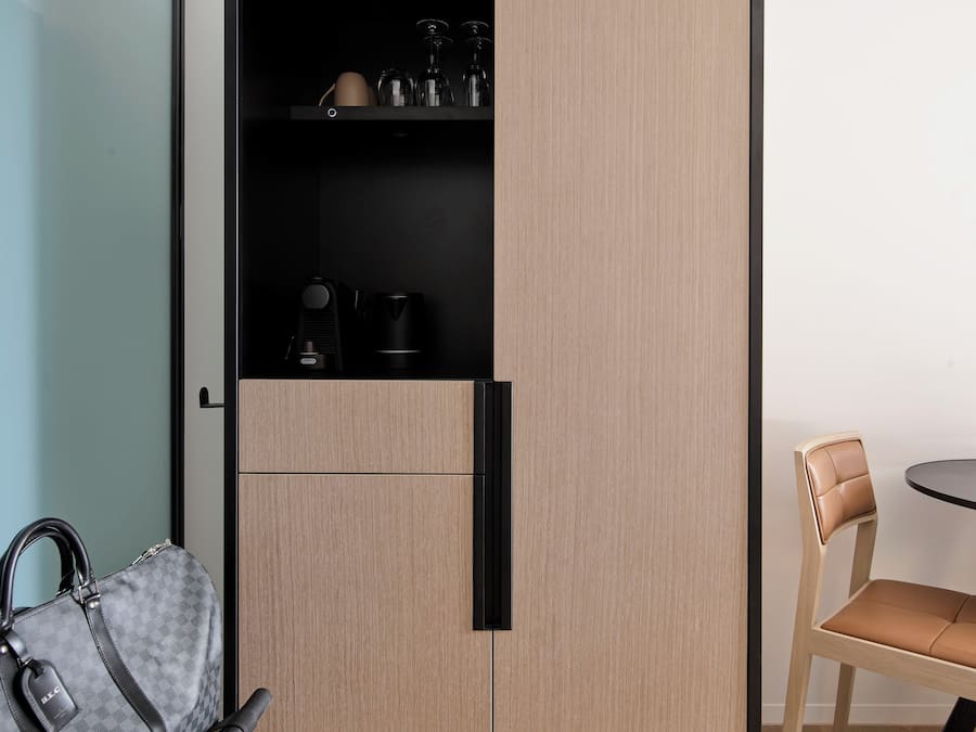 Een moderne kamer met een kledingkast, een eettafel en een stoel.
