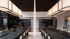 A modern conference room with a long table, chairs, and overhead lighting. - Little National Hotel Sydney (Sydney)