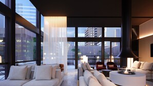 A modern living room with large windows, a round coffee table, and a sofa. - Little National Hotel Sydney (Sydney)
