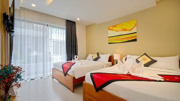 A hotel room with two beds, a painting on the wall, a TV mounted on the wall, and a window with curtains.