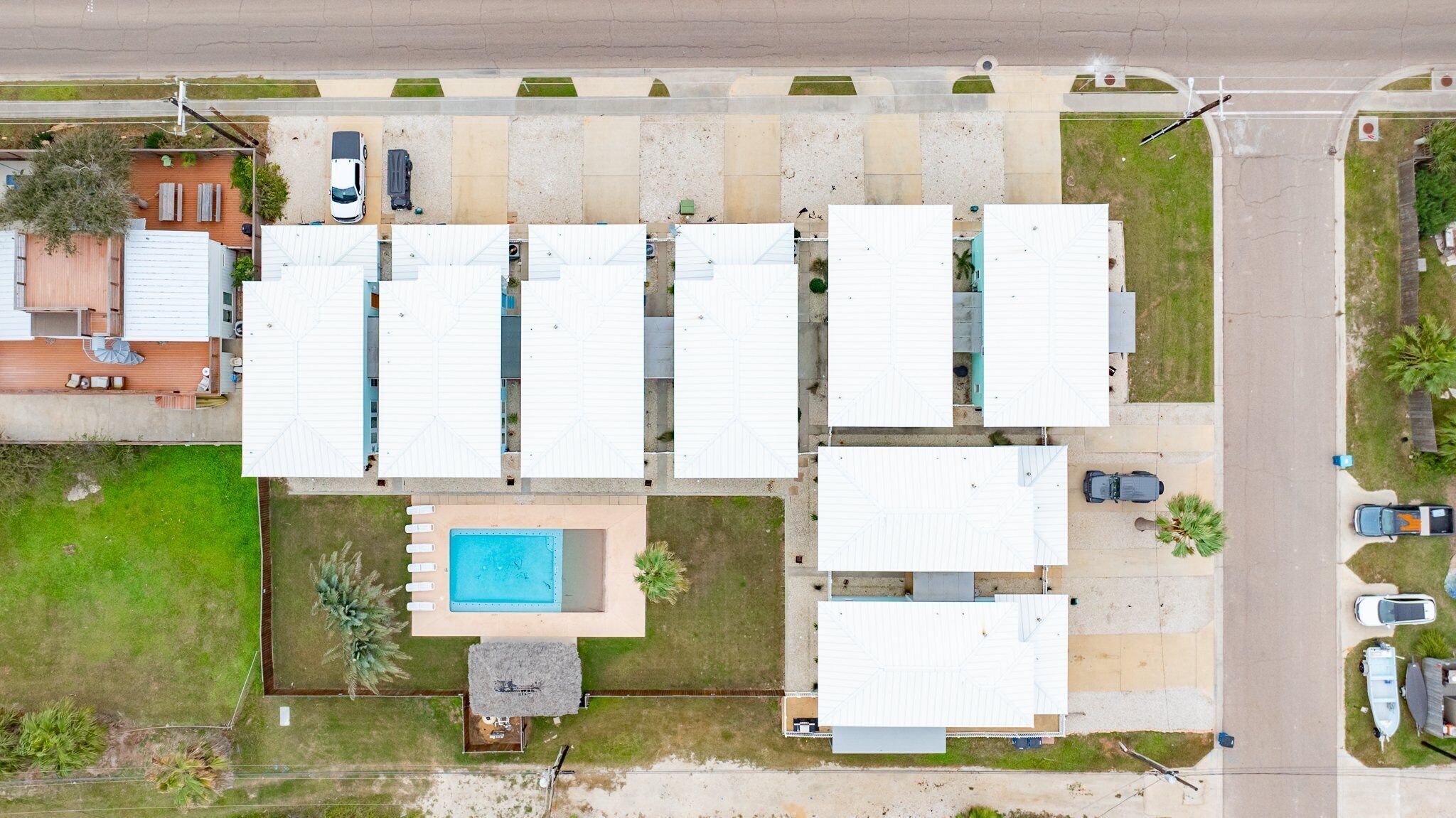 Un quartier résidentiel composé de plusieurs maisons individuelles, d’une piscine et d’un petit jardin.