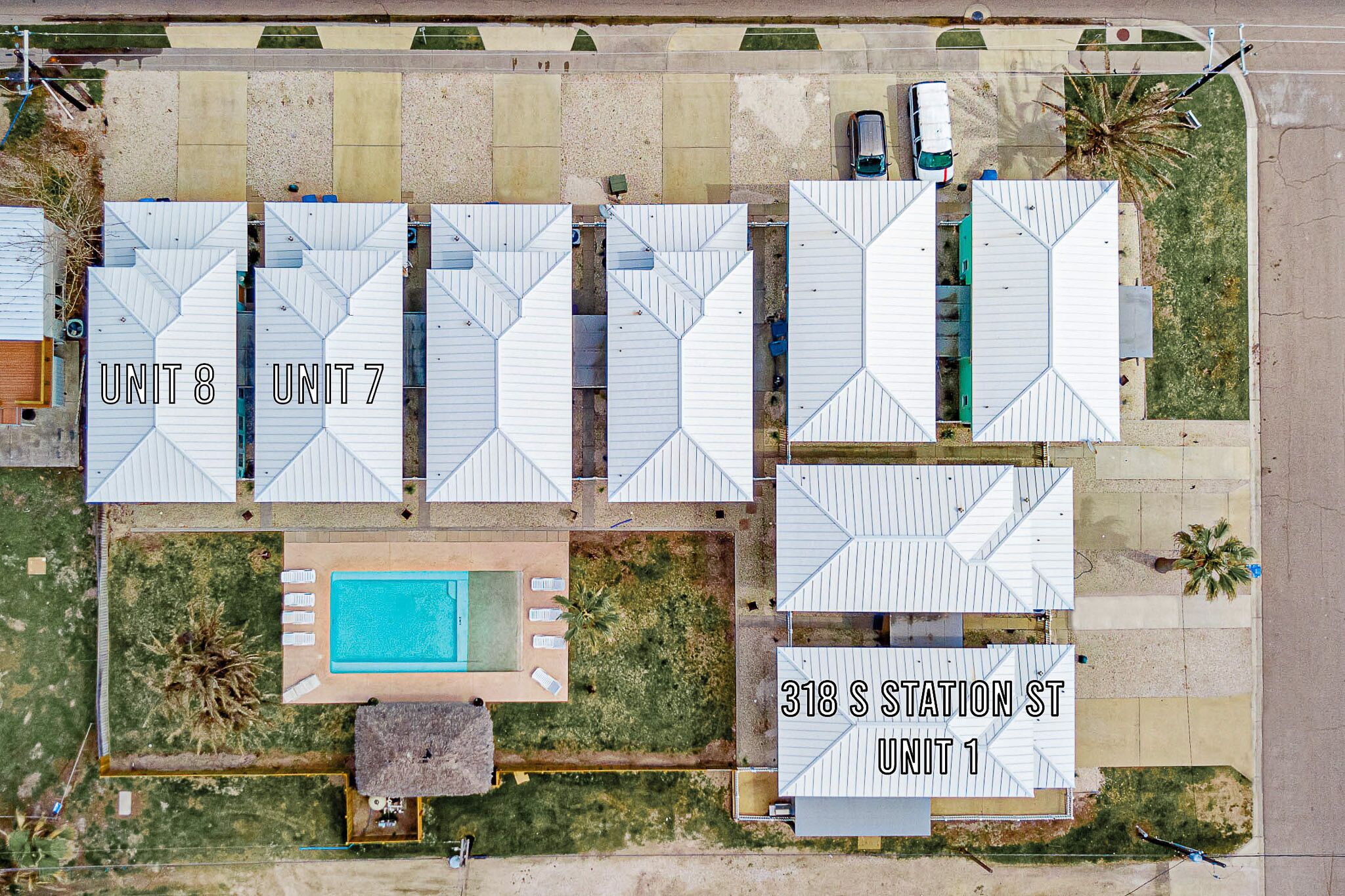 Vista a érea de un hotel con varias unidades, que incluye una zona de piscina y un estacionamiento.