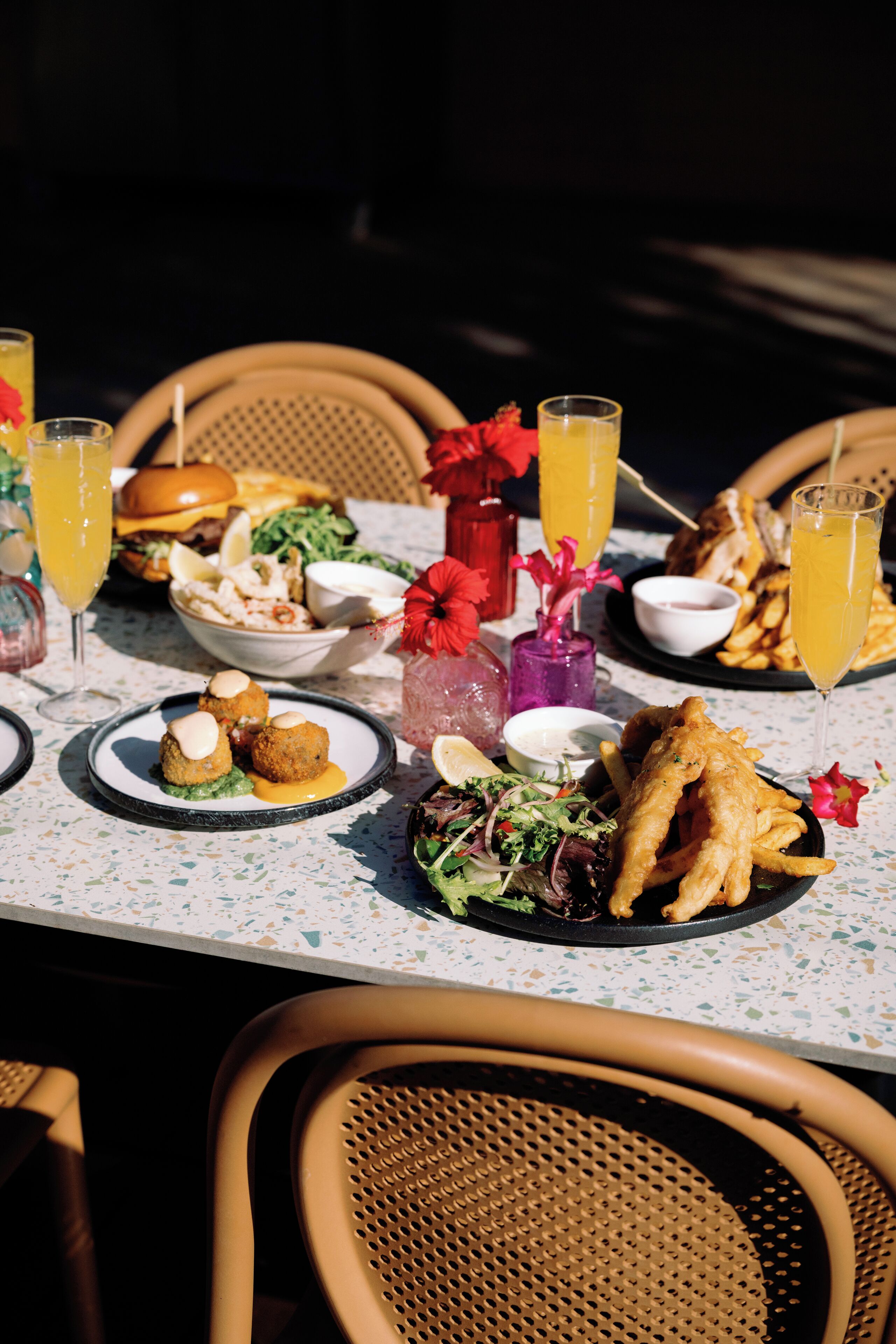 A table set with various dishes, drinks, and a decorative centerpiece.