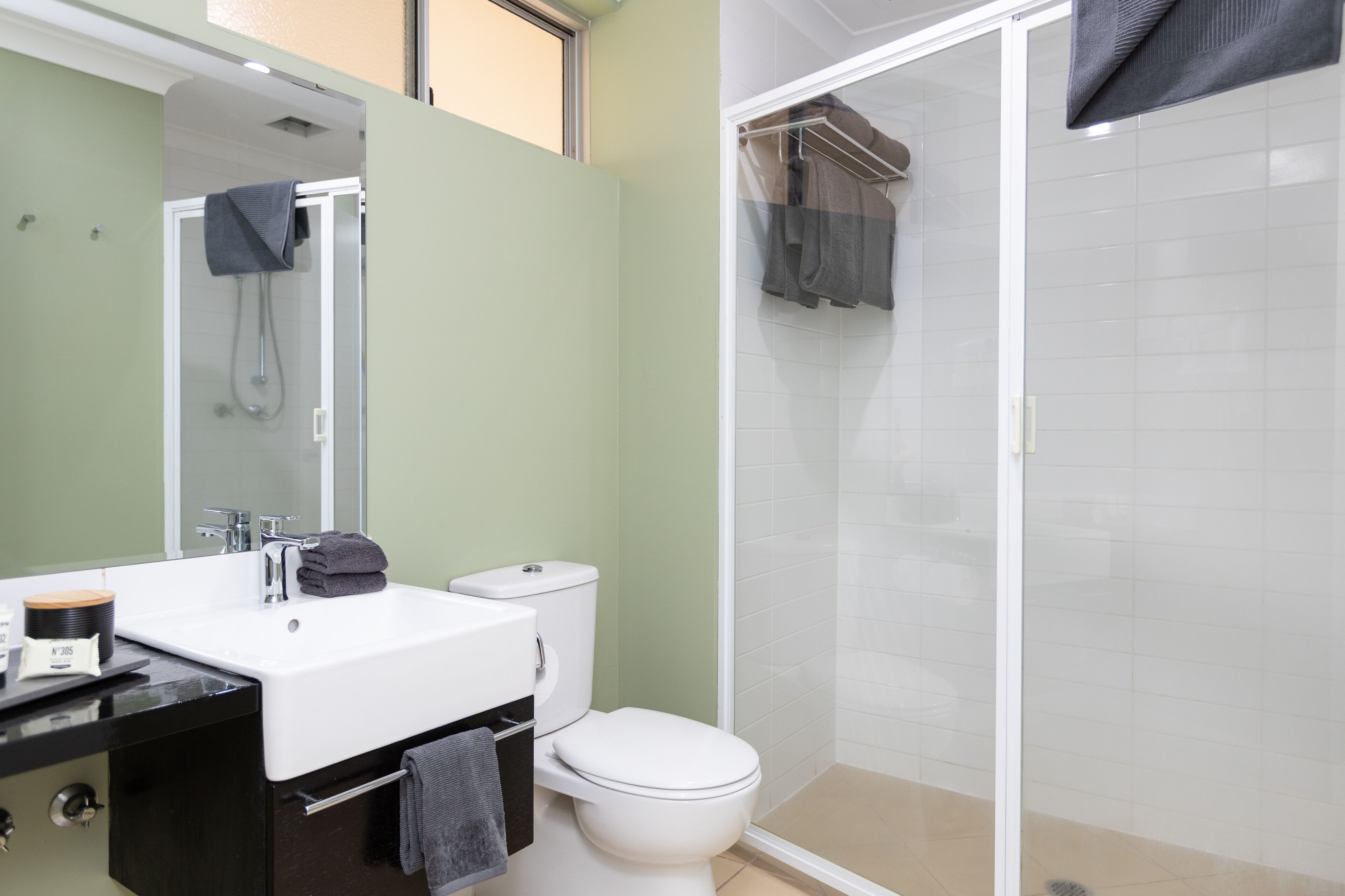A bathroom with a white sink, a toilet, and a glass-enclosed shower area.
