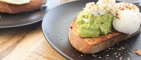 A breakfast plate with avocado toast topped with a poached egg and a poached egg on toast.