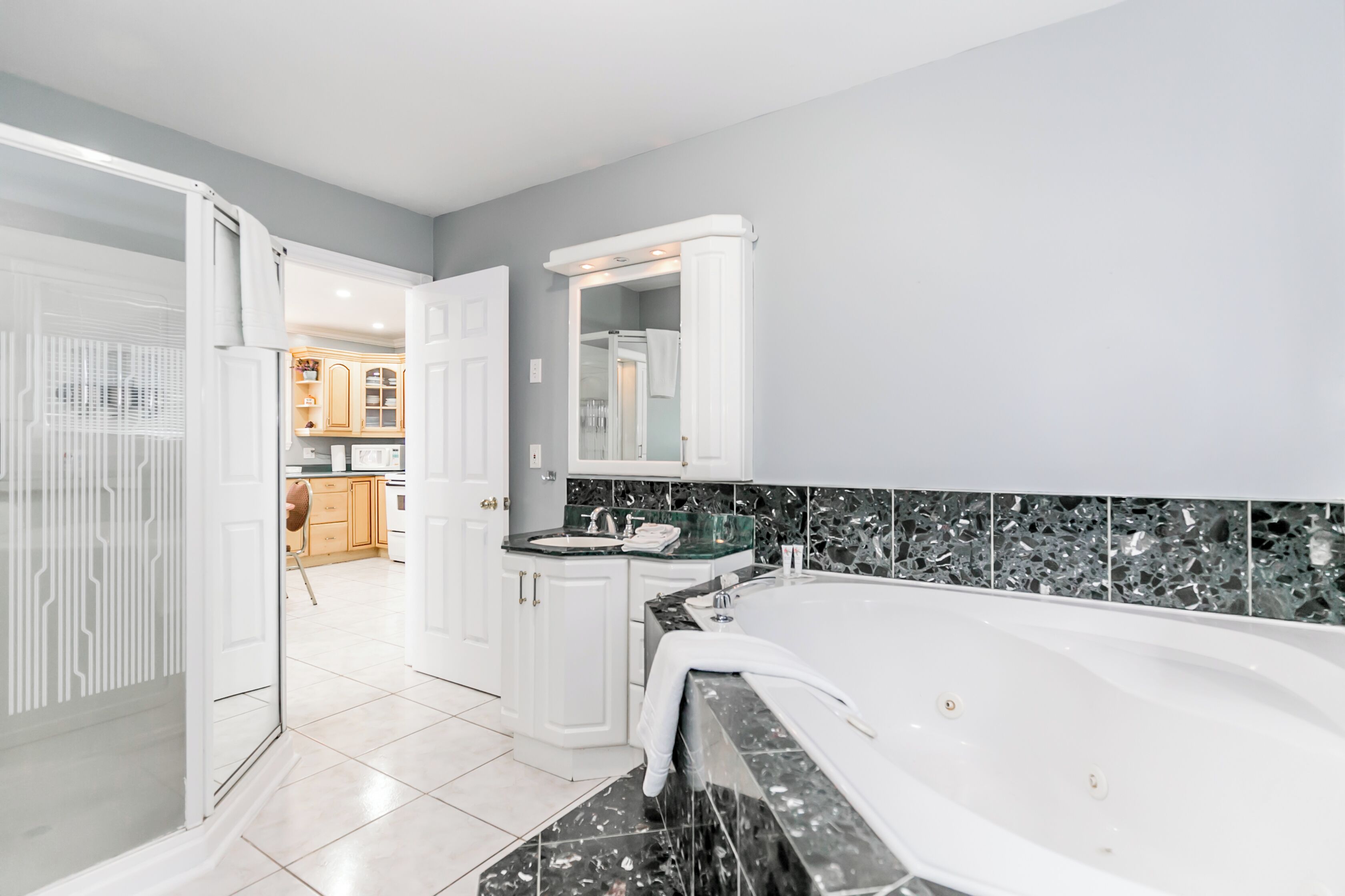 Een moderne badkamer met een bad, een wastafel en een douchehoek.