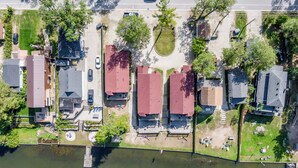 An aerial view of a residential area with houses, a dock, and a river.