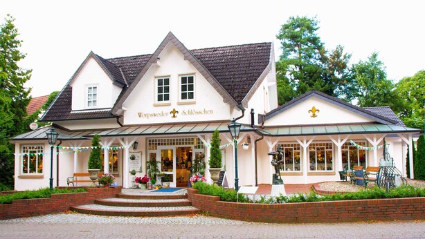 A traditional European building with a sign reading "Worpsweder Schlosschen".
