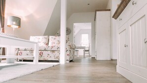 A spacious living area with a sofa, a coffee table, and a dining table with chairs.