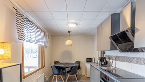 Una cocina compacta con comedor, microondas y horno empotrado.