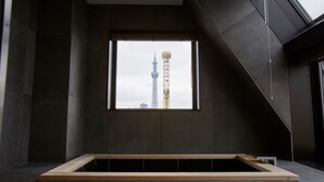 Et moderne interiør med et stort vindue, en træbænk og udsigt til et tårn.