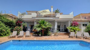A two-story house with a swimming pool, outdoor seating, and a covered patio area. - Beautiful 4 Bed Villa ⭐ Heated Pool ⭐ 650m Beach & Dunas de Artola (Marbella)
