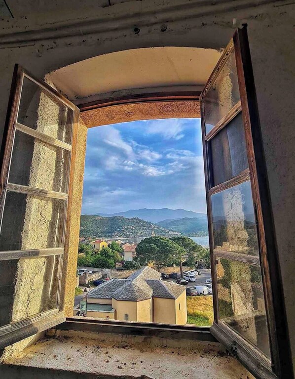 An open window with a view of a coastal town, buildings, and hills in the distance. - ☀ VILLA CARLETTI: 7 PEOPLE - 3 BEDROOMS - 5-MINUTE DRIVE TO THE BEACHES AND SAINT FLORENT (Oletta)