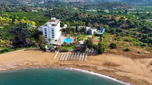 Un hôtel situé sur la côte, doté d’une piscine, d’un court de tennis et d’un espace de plage.