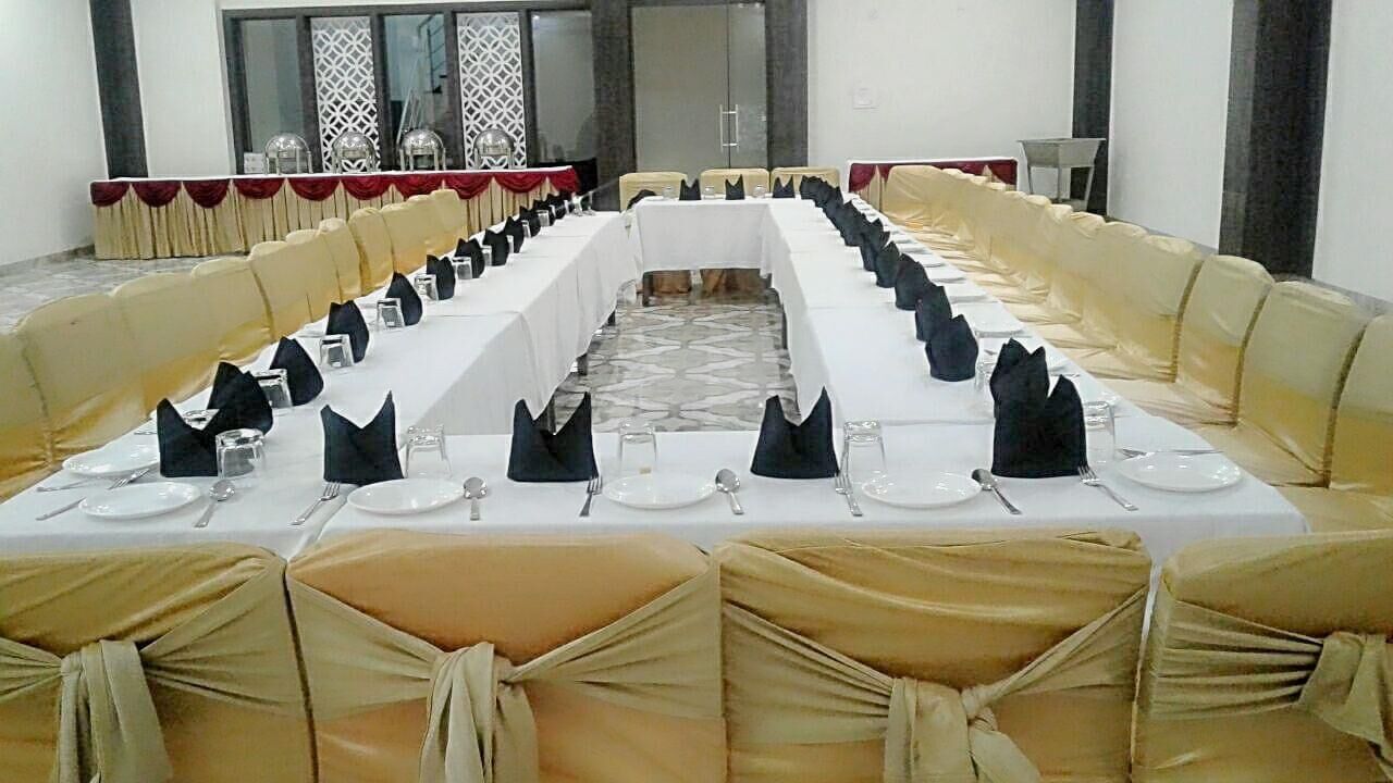 Une salle de conférence avec une longue table préparée pour une réunion, entourée de chaises recouvertes de housses beiges.