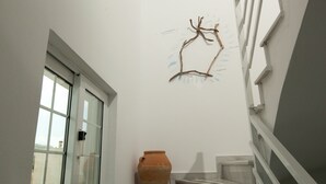 A staircase with a white wall and a window. - Kontogoni Rooms (Elafonisos)