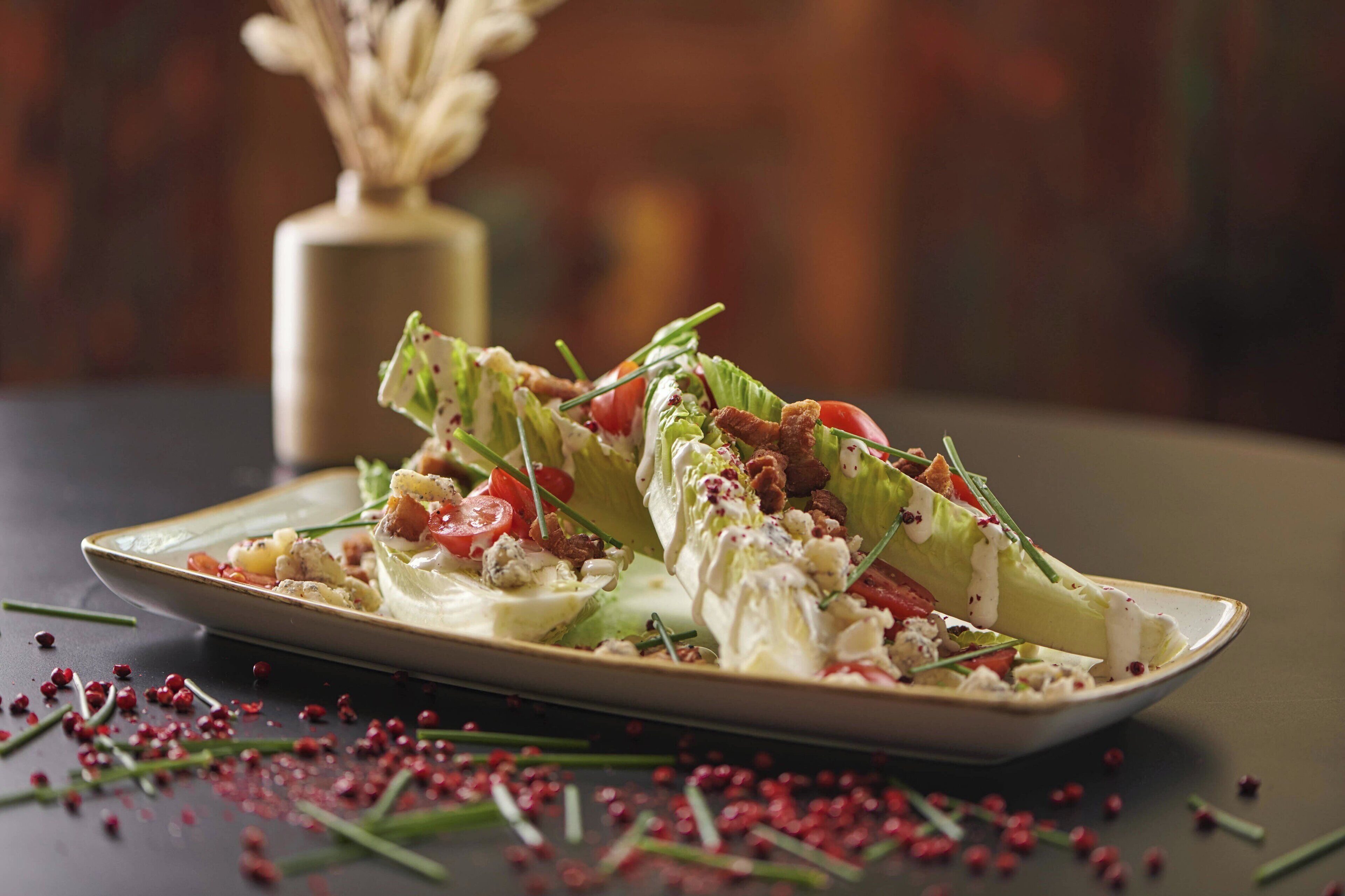 A plate of salad with lettuce, tomatoes, and croutons.