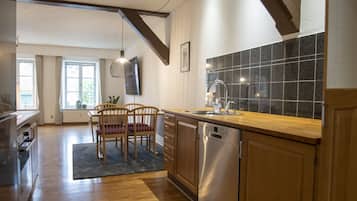 Eine moderne Küche mit Holzschränken, einem Edelstahl-Geschirrspüler und einem großen Fenster.
