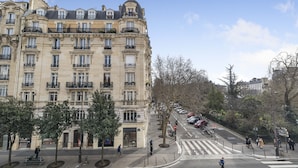 A multi-story building with classical architecture, featuring balconies and large windows.