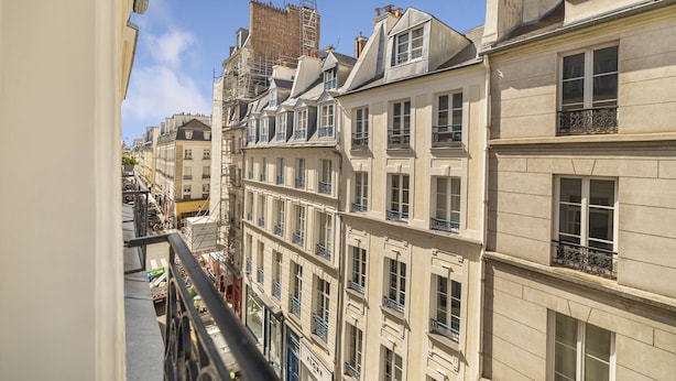 Un immeuble à plusieurs étages doté de balcons, un ciel dégagé et une vue sur la rue.