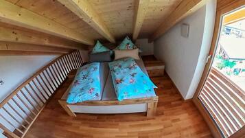 Une cabane en bois avec un lit, une fenêtre et un escalier.