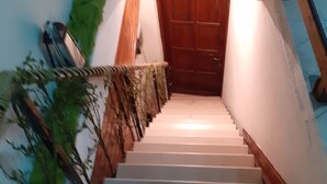 A staircase with a wooden handrail and a wooden door at the top. - Hospitality Home in Asimi , with great location (HERAKLEION,GRETE)