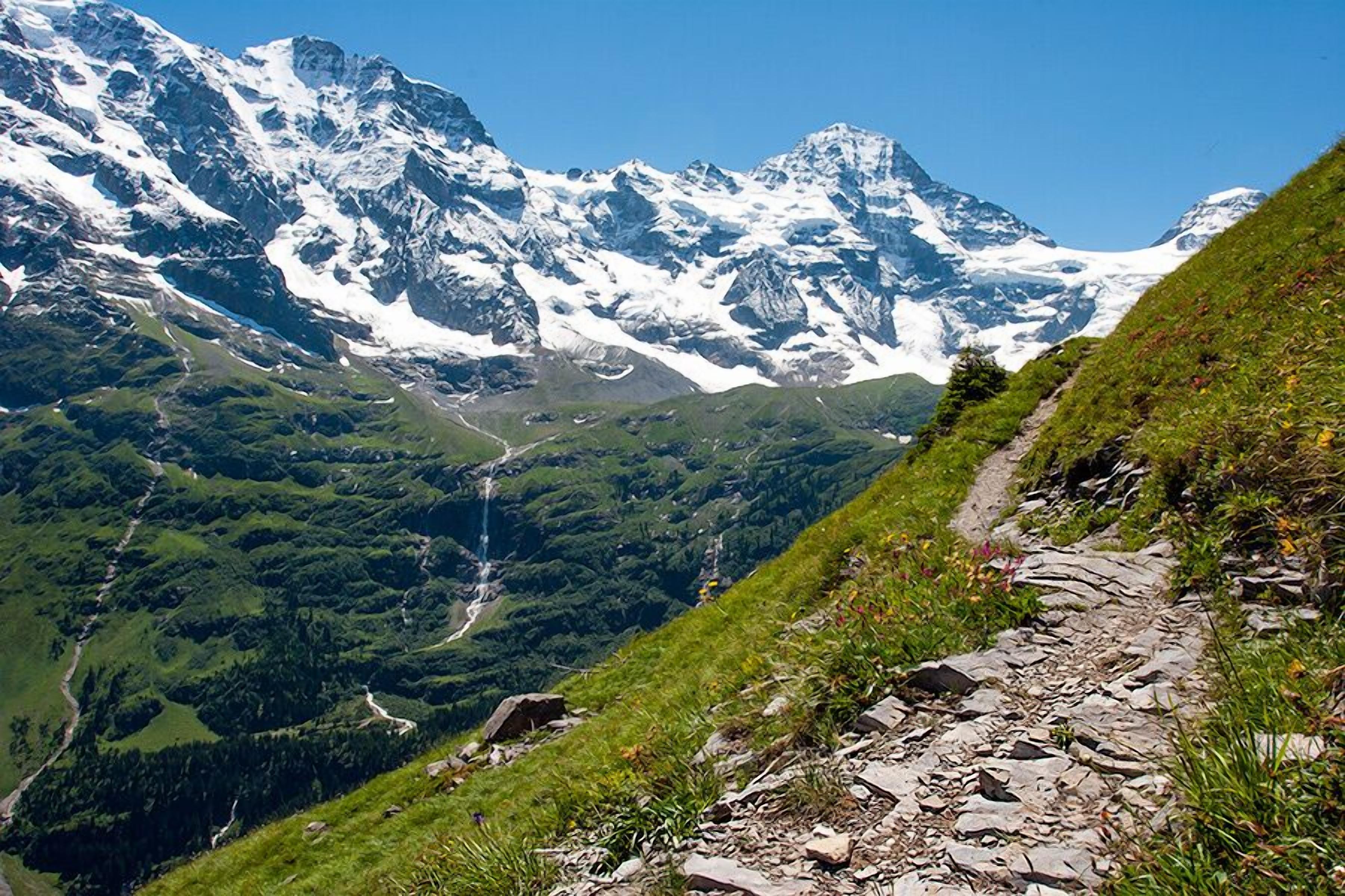 A mountain landscape with a rocky path and a waterfall.