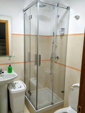 Een bad/douchecombinatie, een haardroger, een bidet, handdoeken