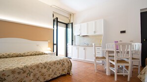 Une chambre à coucher avec un lit, une table de chevet et une fenêtre avec des rideaux.