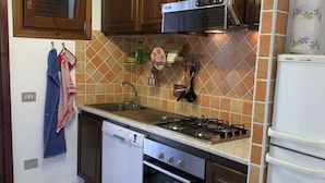 A kitchen with a dishwasher, stove, oven, and a Bosch refrigerator. - I Geranei 3 San Teodoro Centro (San Teodoro)