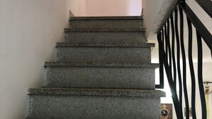 Een betonnen trap met zwarte metalen leuningen.