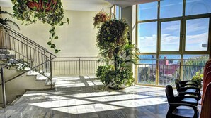 A spacious indoor area with a marble floor, a staircase, and a large window offering a view of the sea. - Benalbeach Apartment with Magnificent Sea View (Benalmádena)