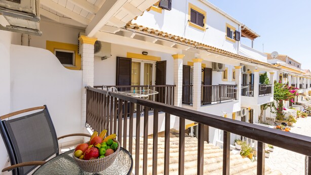 A balcony with a wicker basket of fruit, a glass table, and a chair. - Dora Pool Studios by Konnect, 150m from the Beach (Corfu)