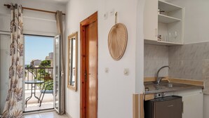 A kitchen with a built-in dishwasher, a small sink, and a wooden door. - Dora Pool Studios by Konnect, 150m from the Beach (Corfu)