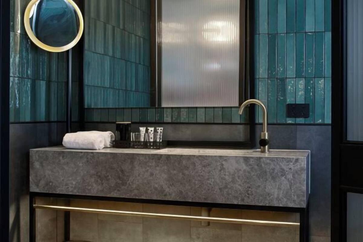 A bathroom with a marble sink, a mirror, and a towel.