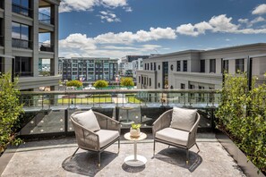 Relax in style on the rooftop terrace with two comfortable chairs and a small table.