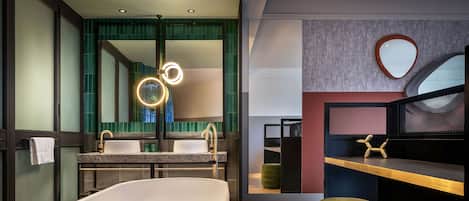 A modern bathroom with a freestanding bathtub, a vanity with a mirror, and a wooden floor.