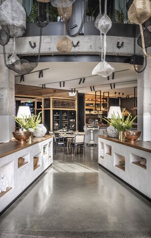 A modern interior with a central bar area, wooden counter, and hanging pendant lights.