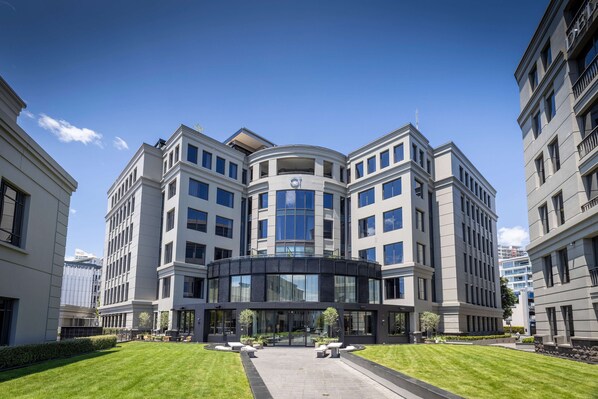 A modern building with a curved facade, large windows, and a central entrance.