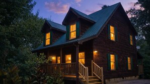 A wooden cabin with a porch and stairs, surrounded by trees. - ♡♡ Cozy, Romantic Getaway w/Hot Tub & WiFi-Central Location (Sevierville)