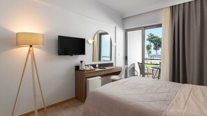 A hotel room with a bed, a desk, a chair, a television, and a view of the outdoors.