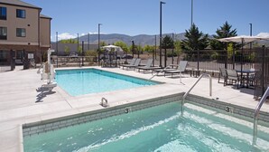 A swimming pool with a view of mountains, lounge chairs, and a covered seating area. - Staybridge Suites Carson City - Tahoe Area by IHG (Carson City)
