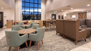A modern hotel lobby with a large window, seating areas, and a reception desk. - Staybridge Suites Carson City - Tahoe Area by IHG (Carson City)