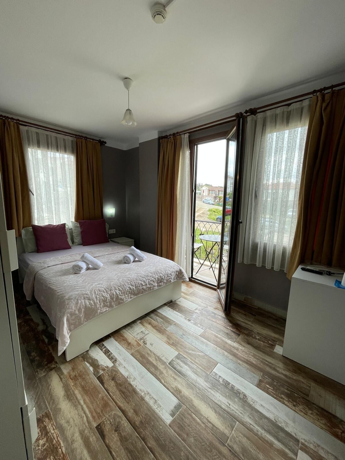 Un dormitorio con cama, escritorio y vista al exterior.