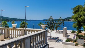 A seaside balcony with a view of the sea, palm trees, and a clear sky. - Villa Ro-ma (Dubrovacko Primorje)