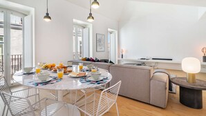 A modern living space with a round dining table, a sofa, and a small side table.