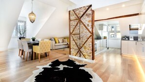A modern kitchen with white cabinets, a wooden countertop, and a hanging light fixture. - Downtown Luxury Duplex | AC | Elevator | Wi-Fi (Lisboa)