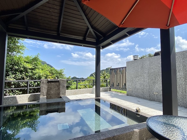 A modern outdoor pool area with a clear view of the surrounding landscape, including trees and a distant mountain. - Jien Mount Villas (New Taipei City)