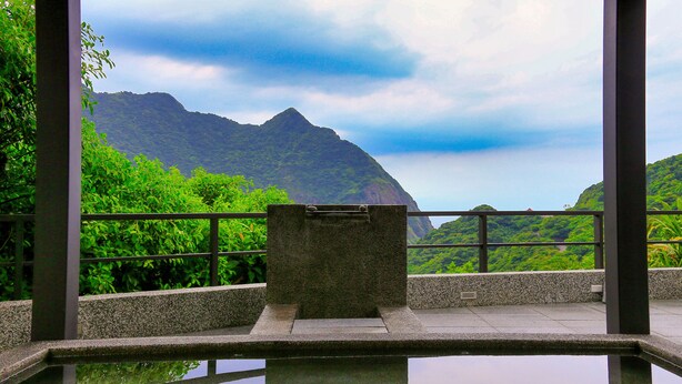 Una piscina interna tranquilla con vista diretta su montagne verdi e rigogliose.