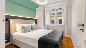 Een slaapkamer met een bed, een raam en een deur.
